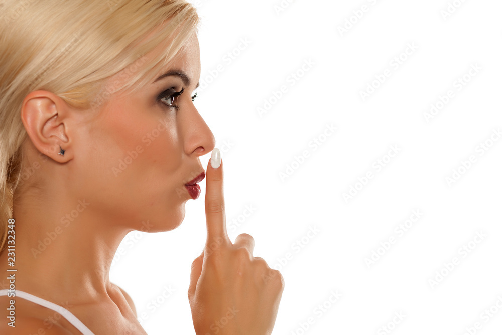 Profile of beautiful girl with finger over her lips on white background Profile of beautiful girl with finger over her lips on white background