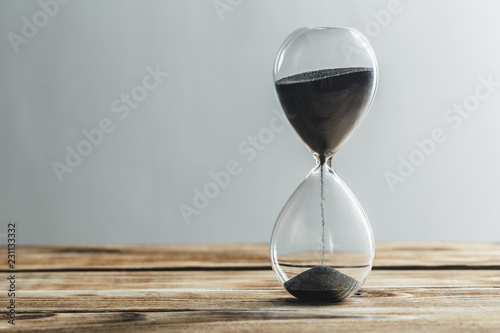Modern hourglass on wooden background