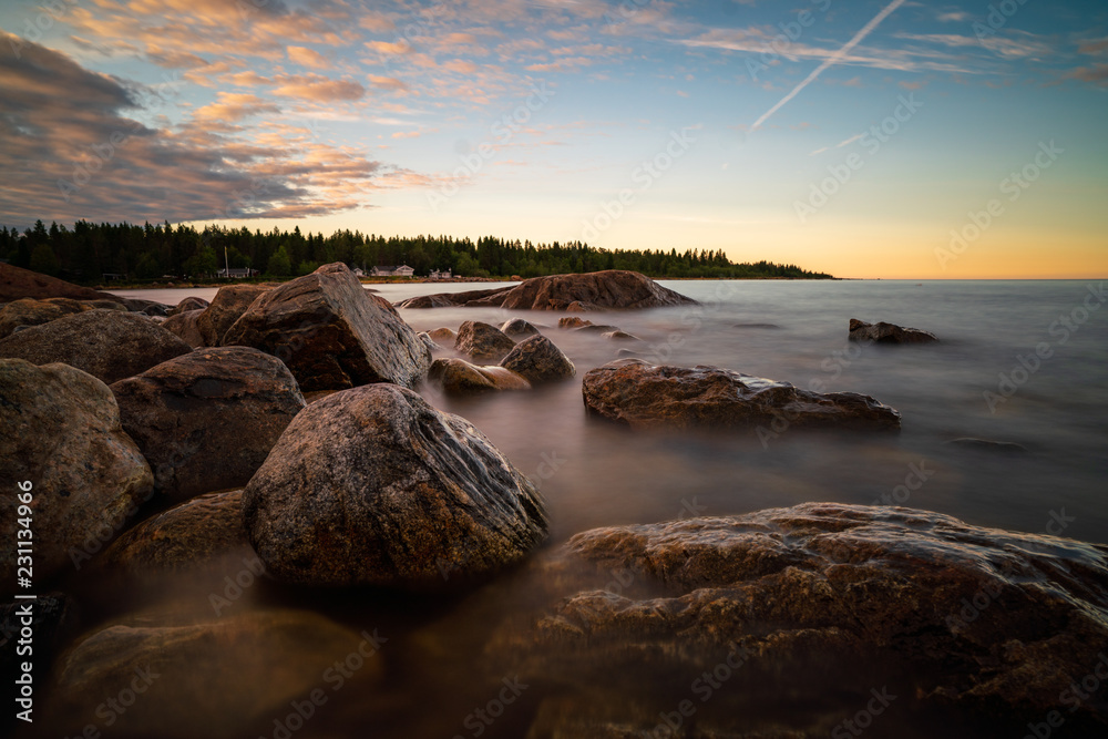 Calm summer sunset over the rocky seashore