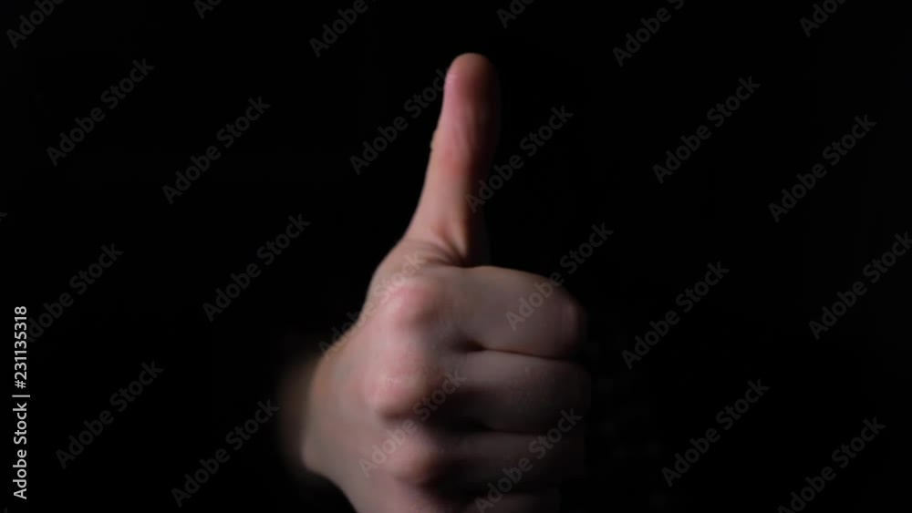 Hand Gestures coming out of the dark into the light. Thumbs up into the camera. 4k slow motion Hand Gestures coming out of the dark into the light. Thumbs up into the camera. 4k slow motion