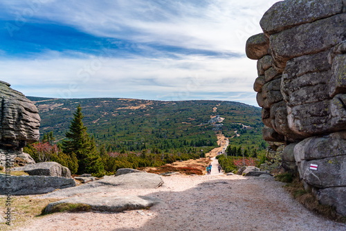 Beautiful path leading through mountain peaks and glades, sunny warm day, heavy rock sculptures creating frame of the photo