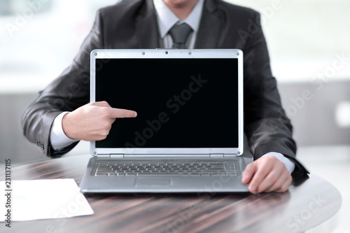 close up.businessman shows a finger on the laptop screen