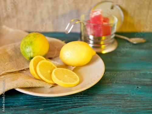 Freshly sliced ​​lemon on a platter, wooden table, apples, sweets, seasonal composition, top view, winter holidays, Christmas