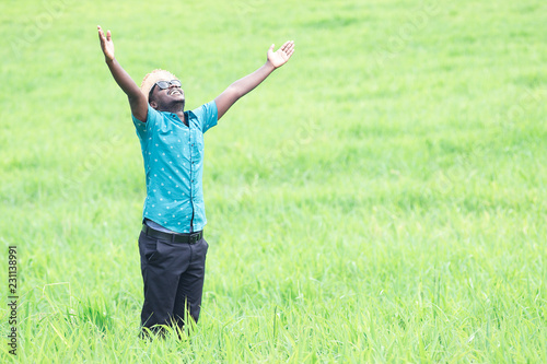 African man travelers stand and smile happily among green meadows.
