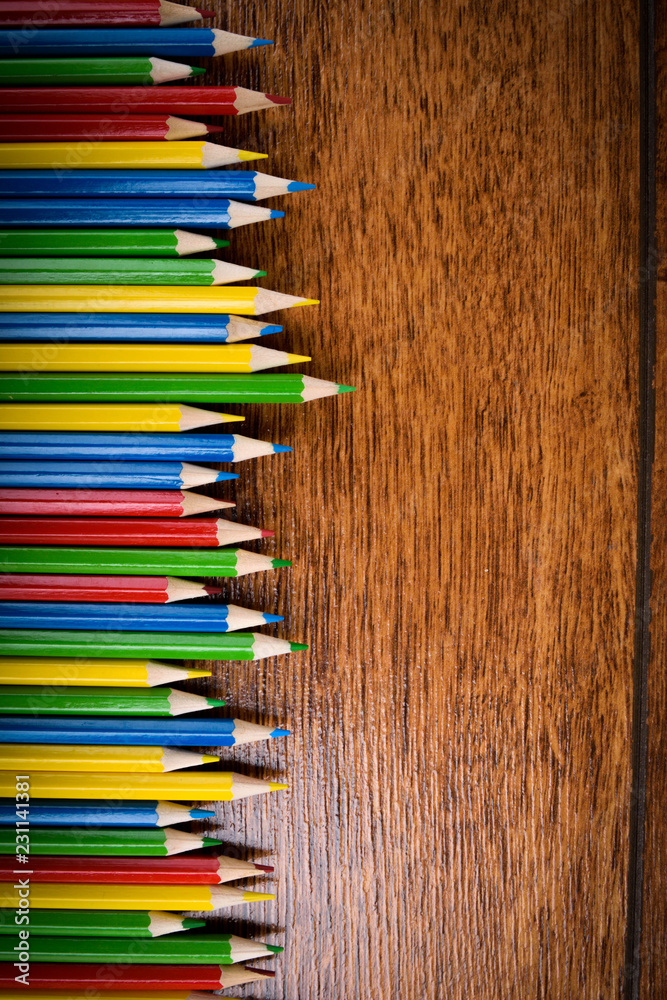 Different colored pencils on the brown wooden table background .Top view .Close up .Color .Pencil.Set Different colored pencils on the brown wooden table background .Top view .Close up .Color .Pencil.Set