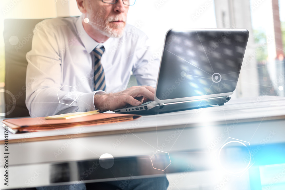 Mature businessman working on laptop, light effect