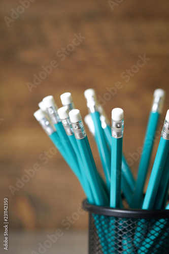 lead blue pencils in black metal holder pot on a wooden background
