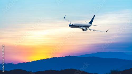 Airplane flying at sunset sky