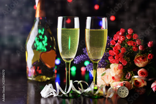 beautiful greeting card banner with champagne glasses and a bottle of golden color with decoration and flowers a bouquet with a clock for the New Year and Christmas photo