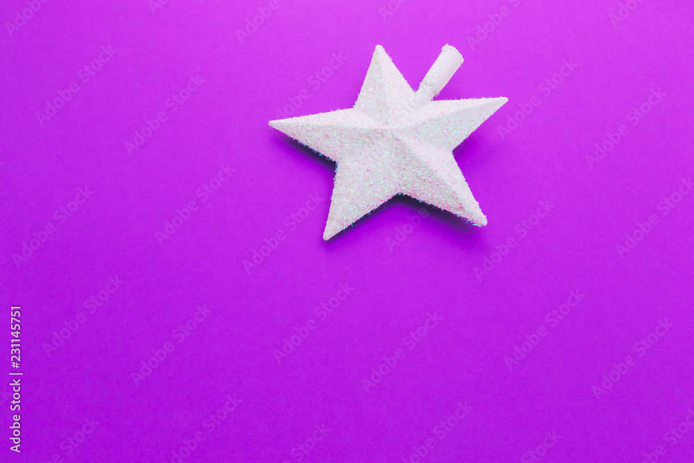 Creative Christmas shiny white star on purple background. Minimal flat lay concept. Space for text and greeting card Creative Christmas shiny white star on purple background. Minimal flat lay concept. Space for text and greeting card