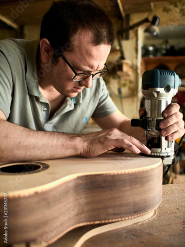 Luthier Install Binding on an guitar. Chamfering on the body of the guitar.