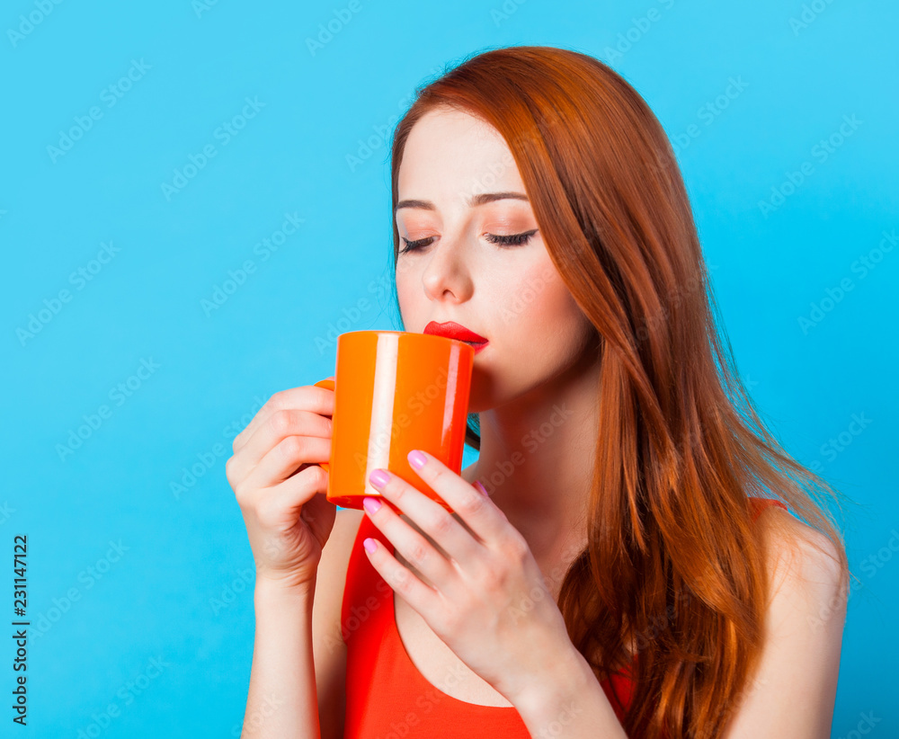 Redhead woman with cup of coffee on blue background. Redhead woman with cup of coffee on blue background.