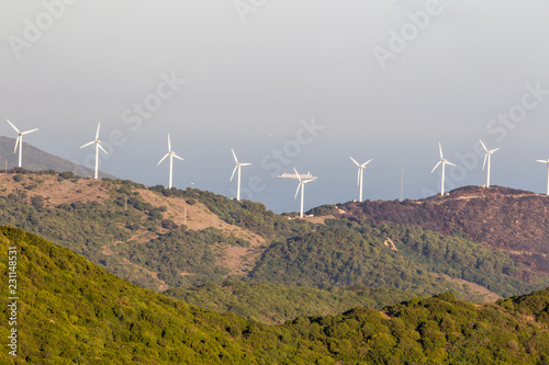 Wind turbines of a wind farm on the wooded mountain peaks of Andalusia in Spain off the Bay of Gibraltar