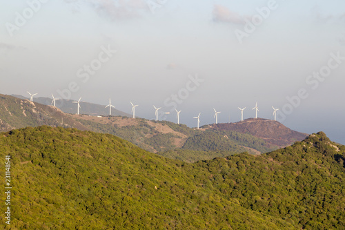 Wind turbines of a wind farm on the wooded mountain peaks of Andalusia in Spain off the Bay of Gibraltar