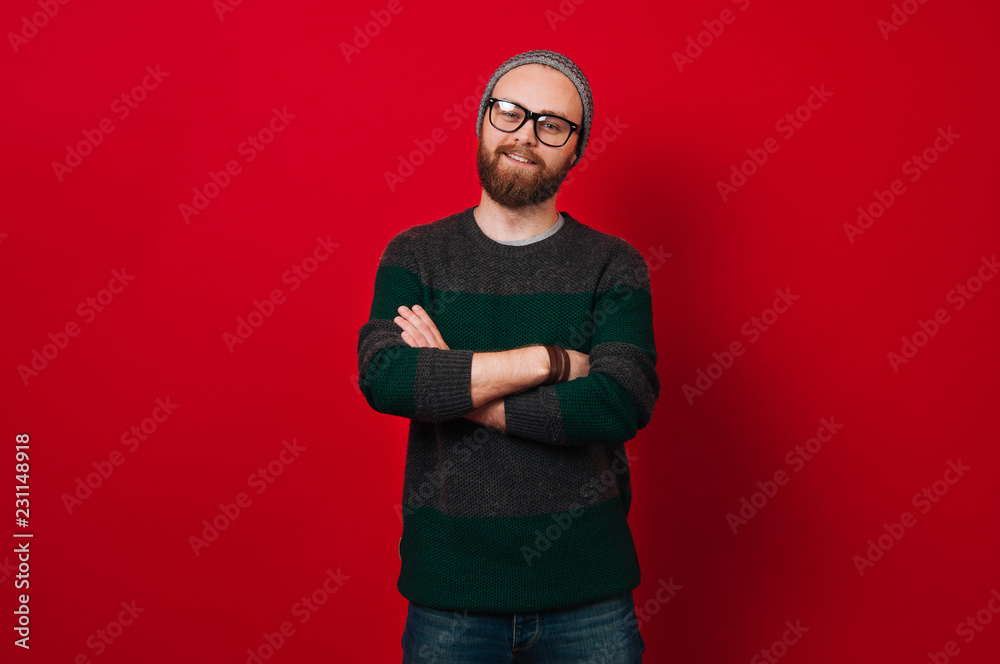 Fototapeta premium Portrait of cheerful bearded hipster man over red background