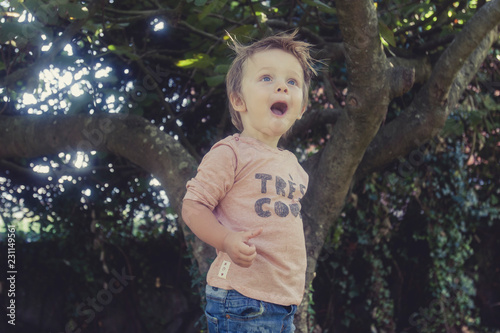 Foto niño con la boca abierta y cara de asombro en un jardín