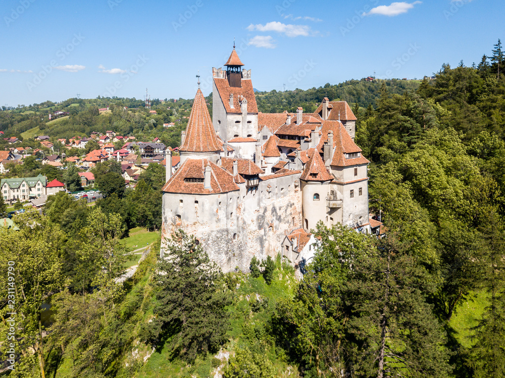Bran castle on a hill with high spires, walls, red tiled roofs, surrounded by Bran town, Wallachia, Transylvania, Romania. Known as Dracula's Castle