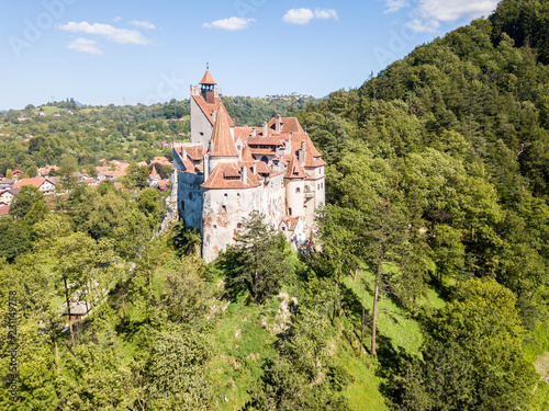 Bran castle on a hill with high spires, walls, red tiled roofs, surrounded by Bran town, Wallachia, Transylvania, Romania. Known as Dracula's Castle