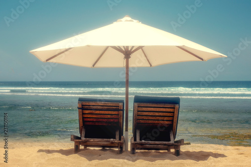 Fototapeta Naklejka Na Ścianę i Meble -  Beach chairs on the beach under a white umbrella. Location coast, sea. Concept vacation