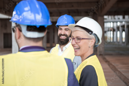 Hipster construction Architect is at a construction site with counterparts and is very happy because they completed the project successfully.