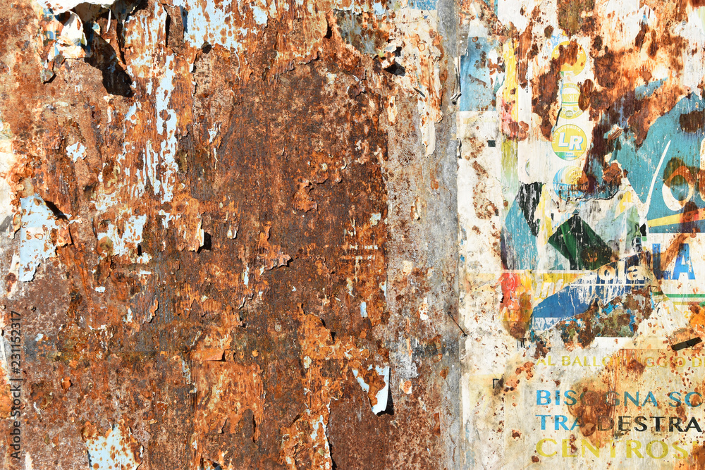 corroded sheet metal background with remains of posters
