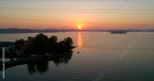 Autumn sunset, C4k aerial, rising drone shot, over the sea, from hietalahti towards keilaniemi and seurasaarenselka, on a sunny and misty, autumn evening, in Helsinki, Finland photo