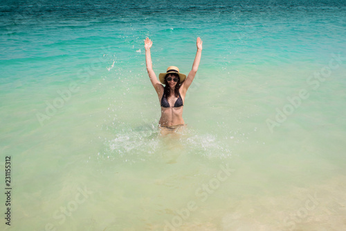 Happy young woman swimming in the azure sea. Funny girl in straw hat