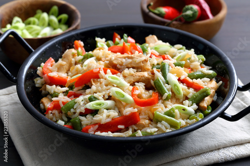 riso con verdure e carne arrosto in tagame di metallo su sfondo grigio