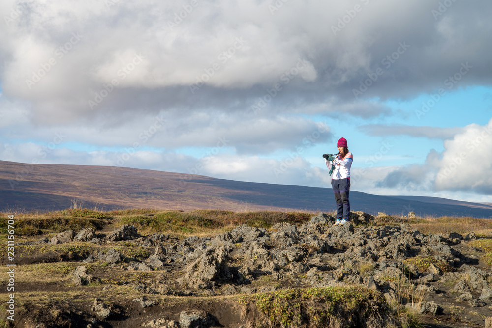 A tourist girl take photo mountain valley near godafoss waterfall, Iceland A tourist girl take photo mountain valley near godafoss waterfall, Iceland