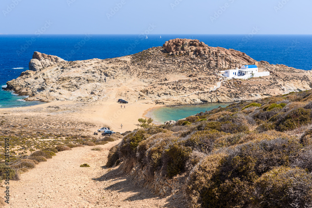 Agios Sostis beach. Sandy beach with the church of Agios Sostis at the edge of the cliff. Cyclades, Greece