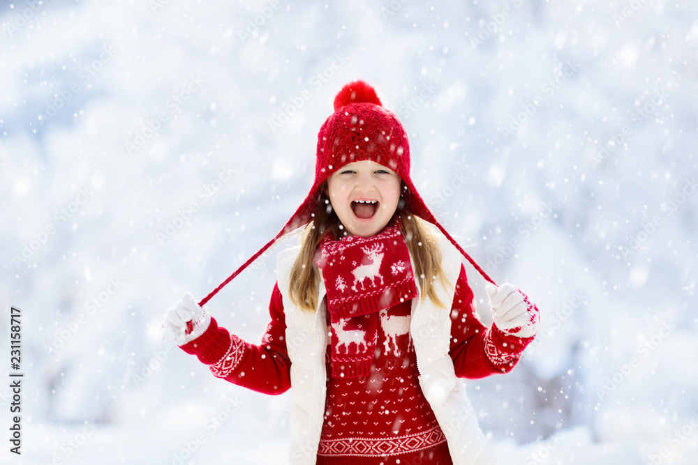 Child playing in snow on Christmas. Kids in winter