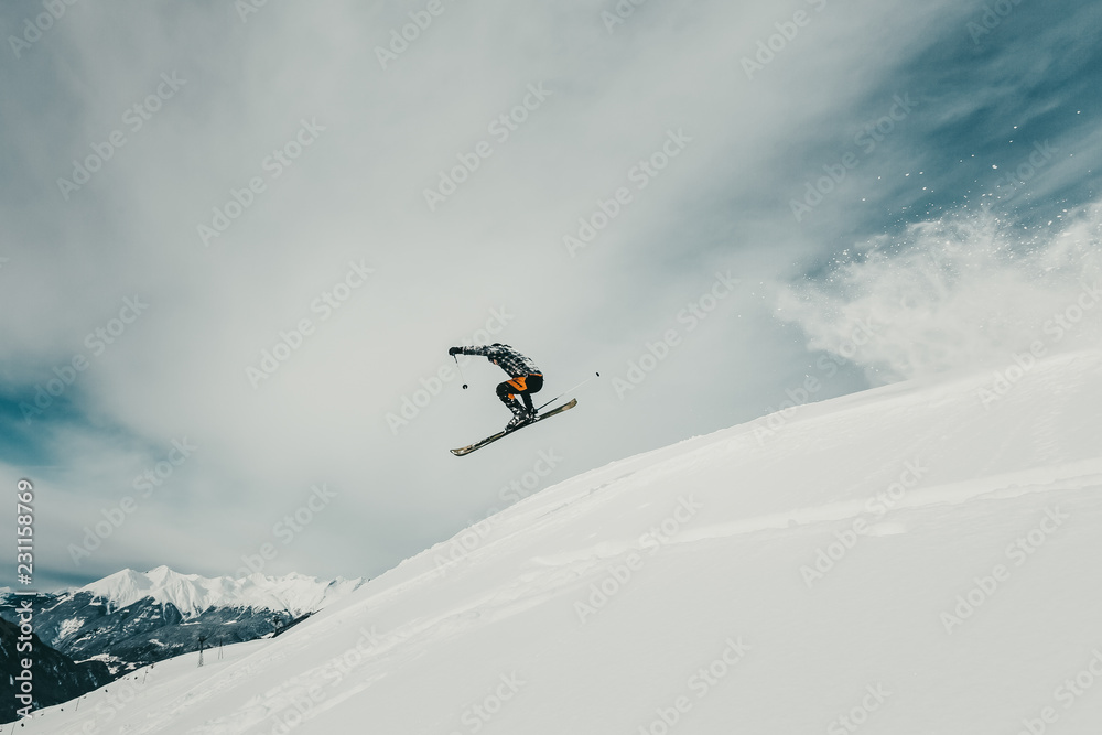 Freeride skier jumping on a ski slope in Switzerland mountains