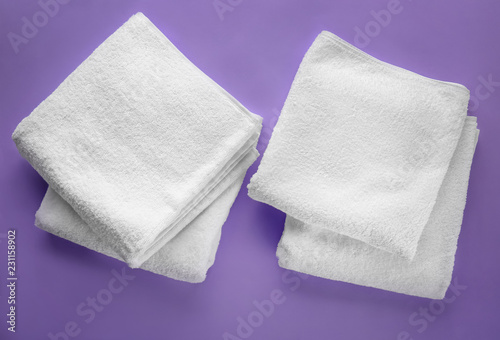 Clean soft towels on color background