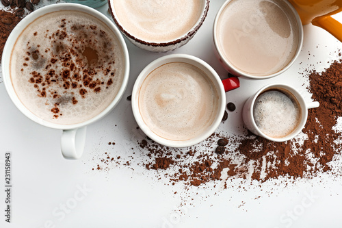 Many cups with tasty aromatic coffee on white background