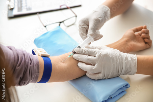 Doctor taking blood sample ...