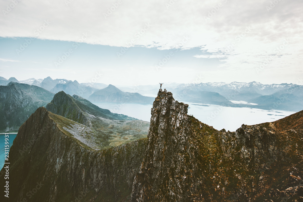 Norway mountaineering travel man standing on cliff mountain top above fjord adventure climbing extreme lifestyle journey vacations aerial view landscape