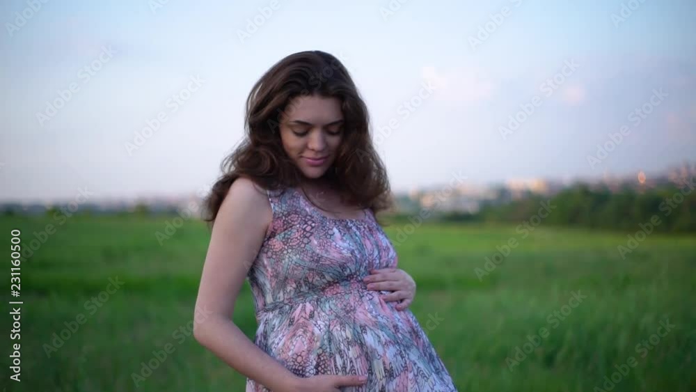 happy pregnant woman touching her belly on nature happy pregnant woman touching her belly on nature