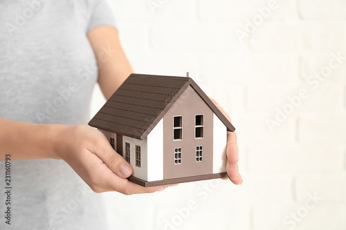Woman with model of house o...