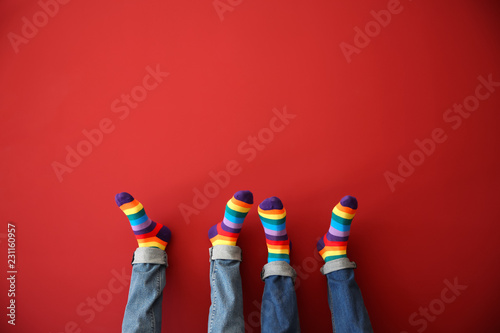 Gay couple with rainbow socks on color background