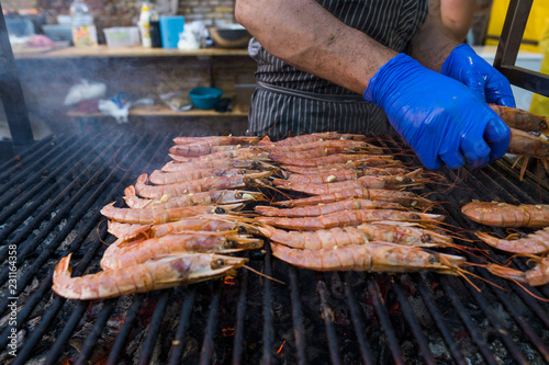 Cooking fresh king's shrimp on a grill on a foodfest. photo