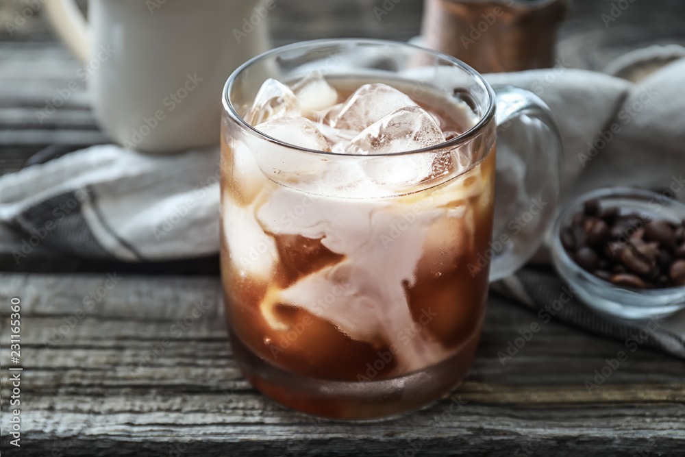 Glass cup with cold coffee on wooden table Glass cup with cold coffee on wooden table