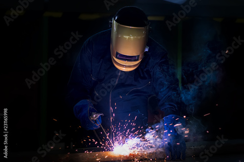 Working person About welder steel Using electric welding machine There are lines of light coming out and safety equipment.