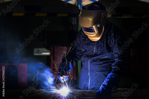 Working person About welder steel Using electric welding machine There are lines of light coming out and safety equipment.