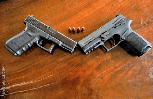 Two pistols on a wooden background. With a difference