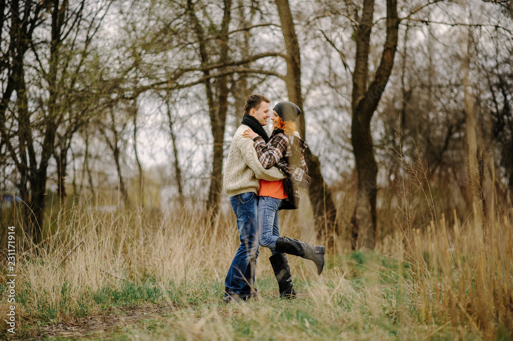 Young couple walks in autumn forest. Man giving his girlfriend piggyback. People having fun outdoors Young couple walks in autumn forest. Man giving his girlfriend piggyback. People having fun outdoors
