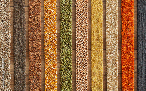 Various seeds and grains arranged in colorful stripes on the table - top view