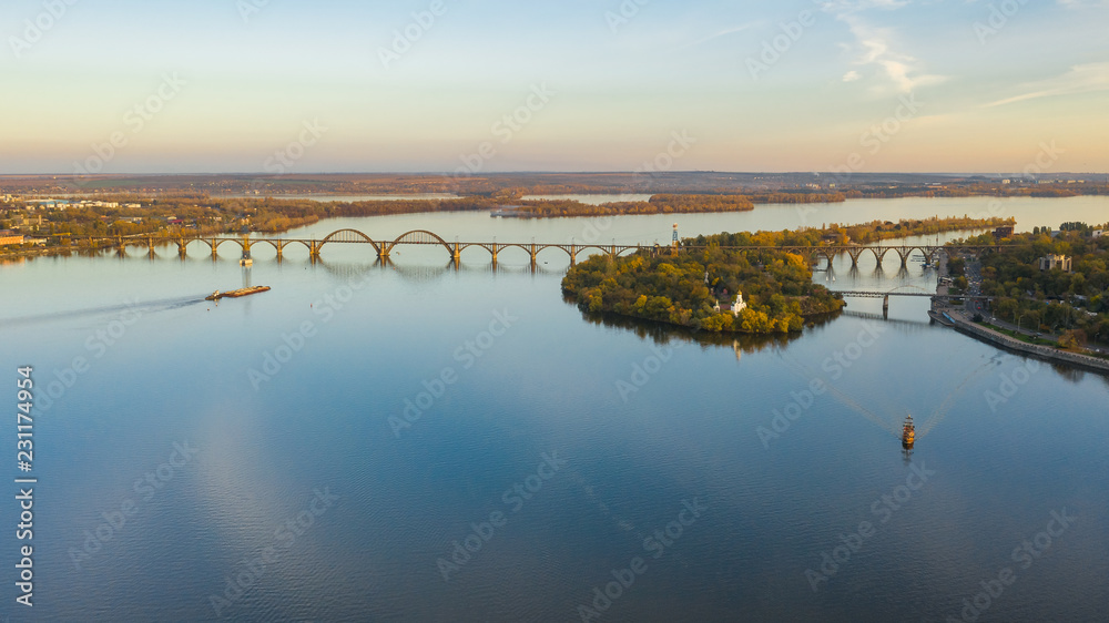 Aerial top view from drone on railway bridge above Dnieper river in Dnipro city. Autumn landscape and cityscape background. (Dnepr, Dnepropetrovsk, Dnipropetrovsk)