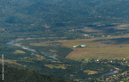 A view of a winding mountain river from the top of the mountain. a view from the mountain range to the river flowing along the mountains in the Carpathians