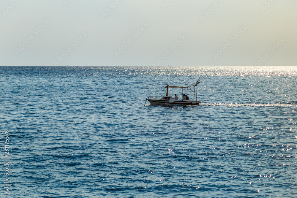 Boat in the calm sea against the sunset sky Boat in the calm sea against the sunset sky