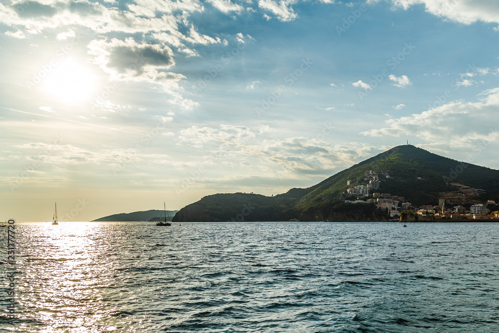 View of the coast near the town of Budva from the sea against the setting sun